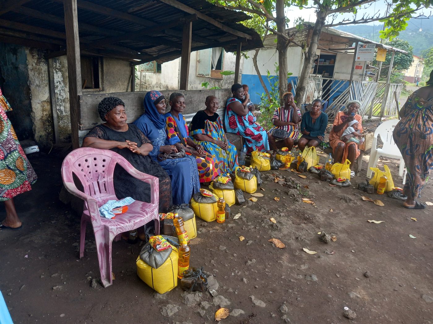 Women seated with supplies at Limbe Camp outreach
